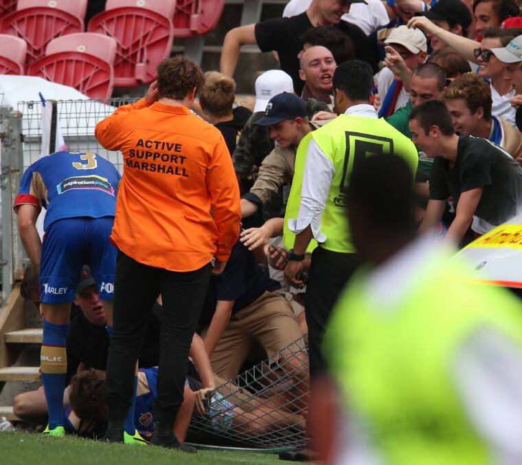 DOWN: Jets fans on the ground after the fence gave way on Sunday. Pictures: Grant Sproule