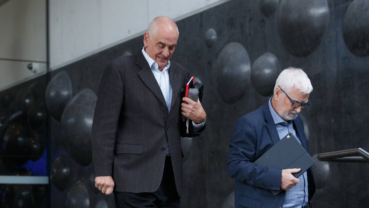 DAY ONE: Graeme Lawrence leaves the Newcastle court with his lawyer John Anthony on Monday after the first day of his sexual assault trial. Picture: Max Mason-Hubers