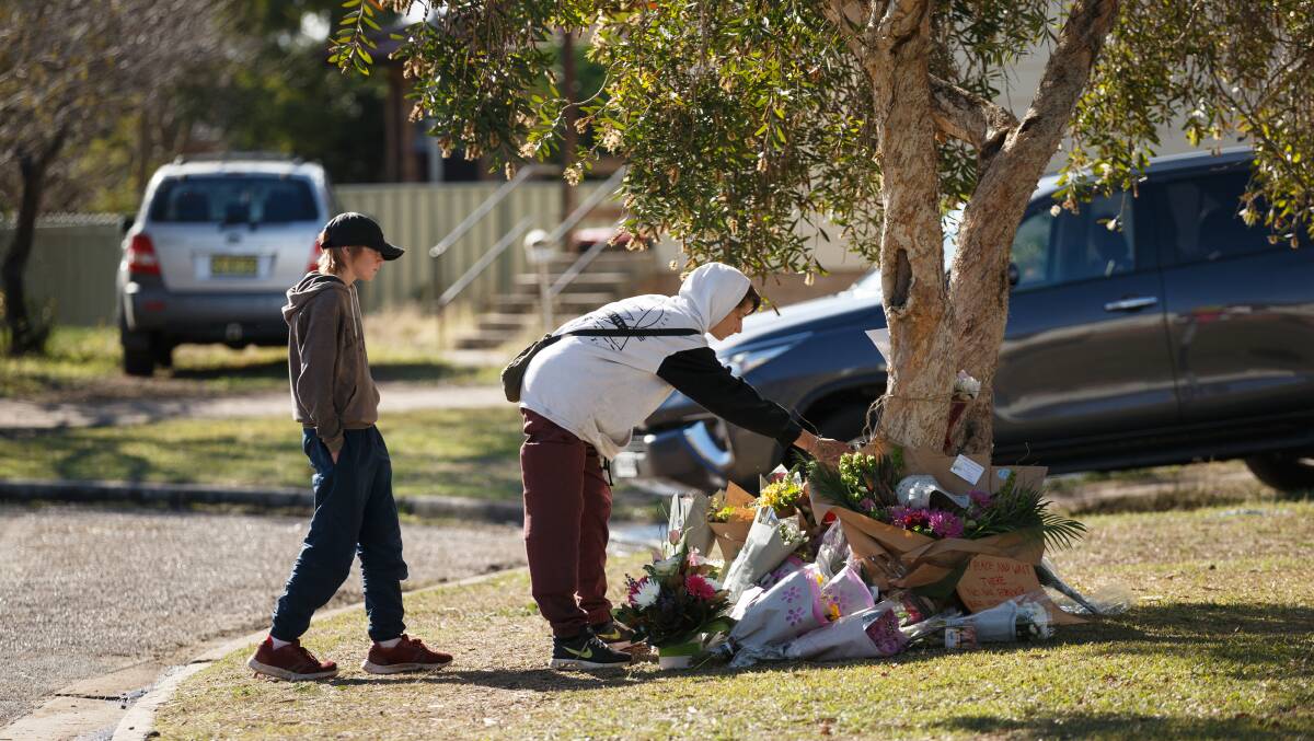 REMEMBERED: Storm Smith, 16, and Cody Forbes, 15, pay their respects at the memorial outside the house. Pictures: Max Mason-Hubers 