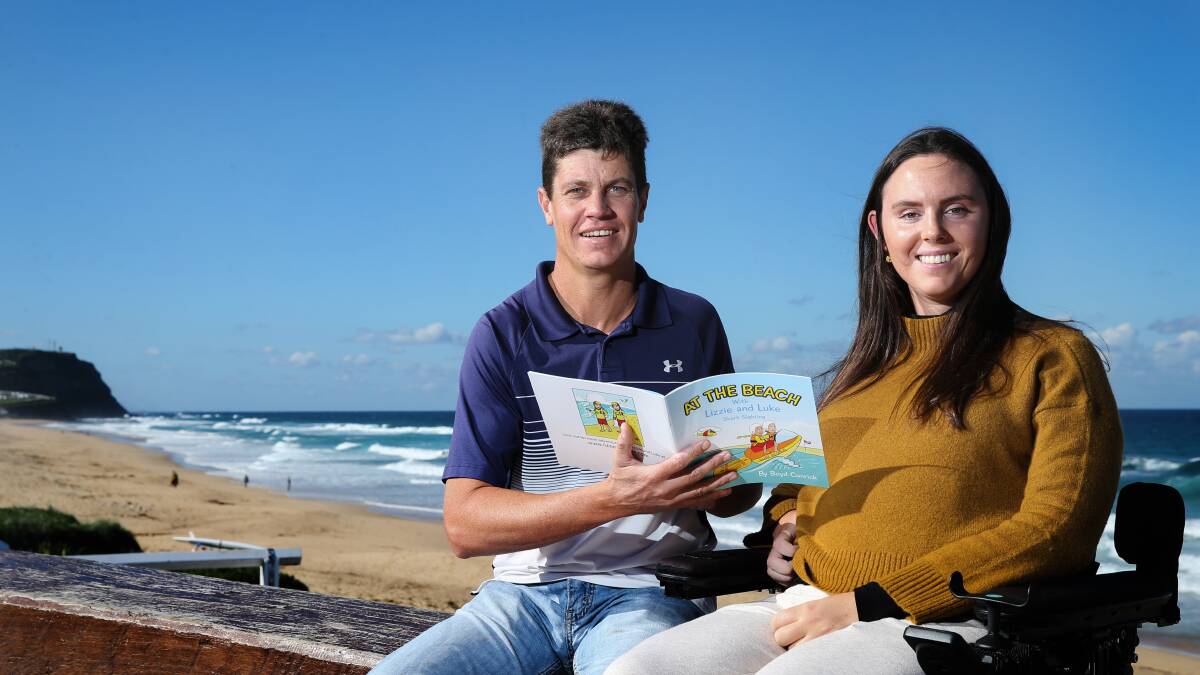 Author Boyd Conrick and Jess Collins with a copy of 'At the Beach with Lizzie and Luke - Shark Sighting' on Wednesday at Merewether Beach. Picture: Marina Neil