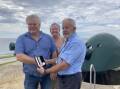 Fort Scratchley curator Ron Barber, right, hands over the once lost WWI medal to Michael and Lynette Martin. Picture: Mike Scanlon 