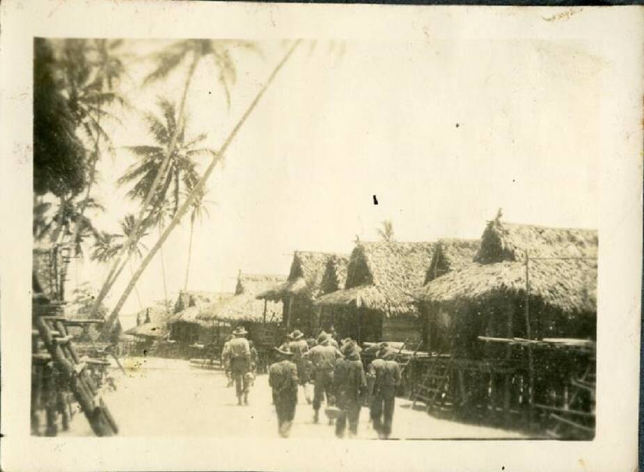 VILLAGE PATROL: Australian infantryman inspect a typical village in Papua New Guinea. Image: The University of Newcastle's Cultural Collections