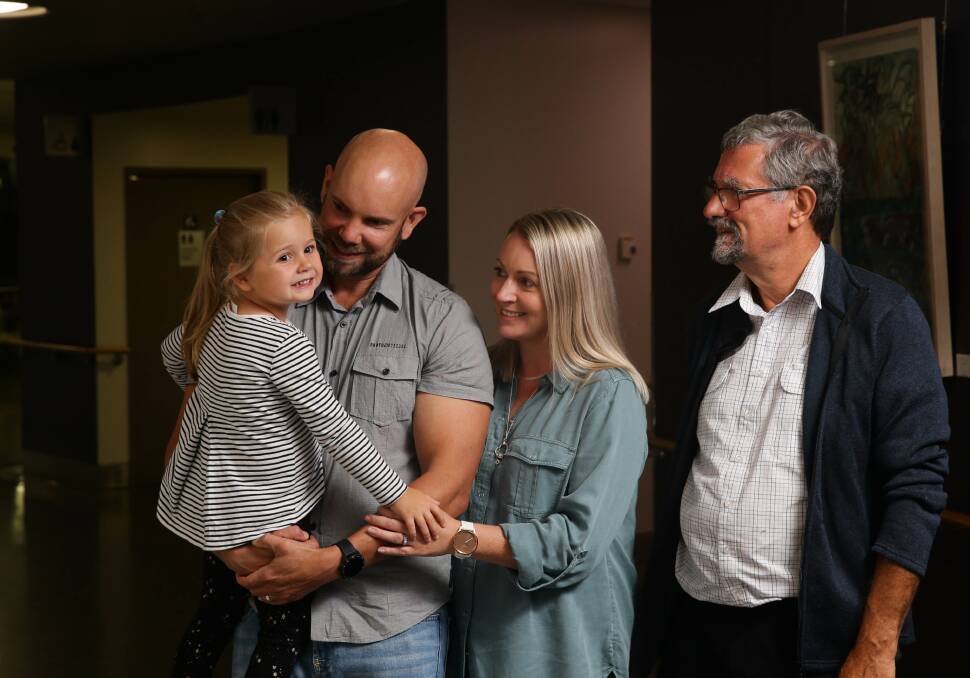 Trusted hand: Dr Henry Murray, right, reunites with Enid, 4, and her parents Philip and Casey Smith. Dr Murray gave Enid a life-saving blood transfusion while she was still in the womb. After a 40-year career in obstetrics, he is retiring. Picture: Jonathan Carroll