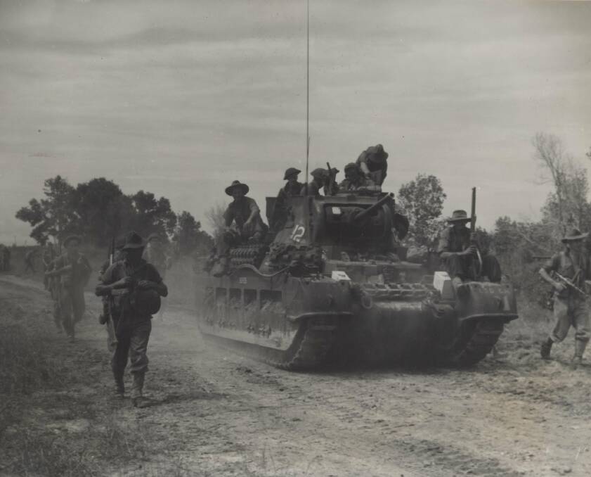 MIGHTY: Australian infantrymen ride on a Matilda tank while their mates walk. Matildas were first used in Bougainville 75 years ago last week. Image: UoN's Cultural Collections