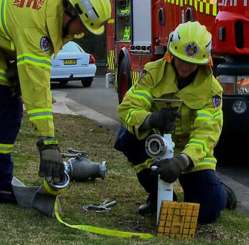 EASY ACCESS: Firefighters use a water hydrant on a footpath. 