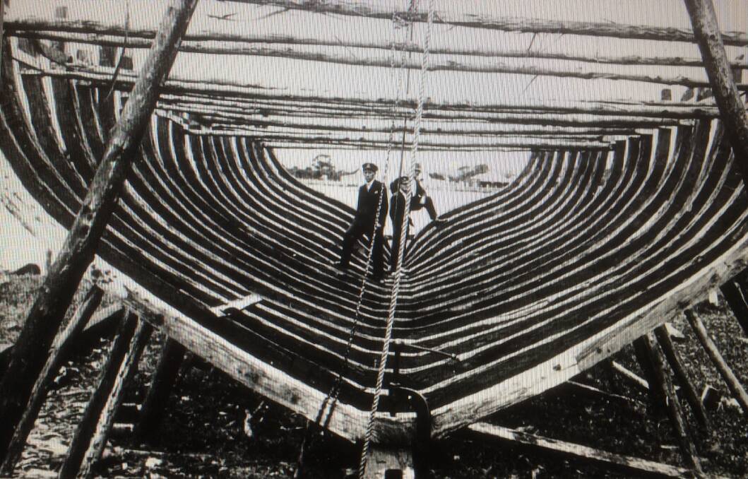 Strange sight: Visitors inspect the hull of the yet to be launched timber motor vessel, Erina 11, at Empire Bay in 1933. 