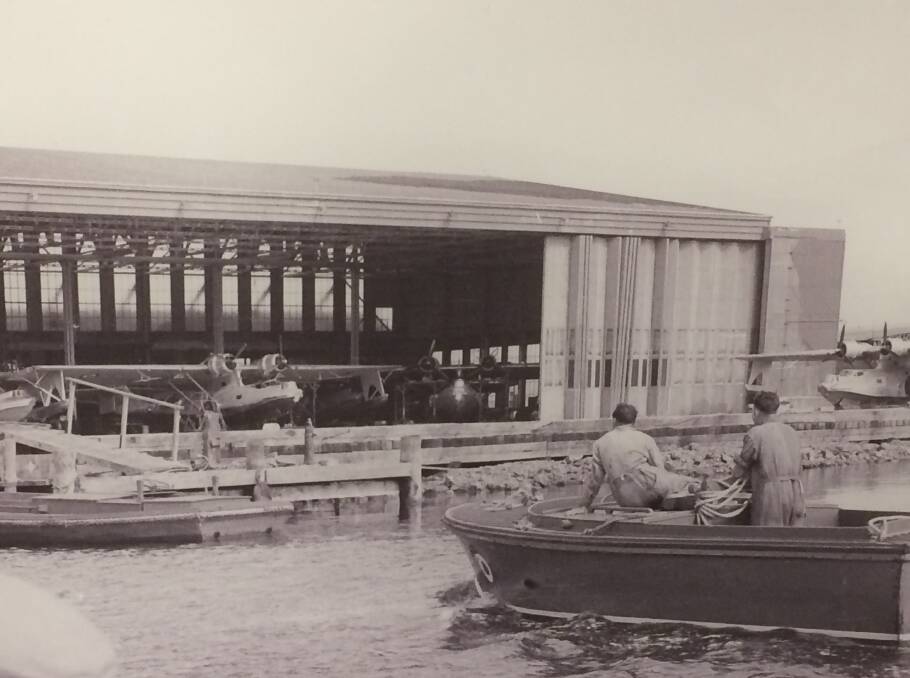 Scene long gone: One of Max Dupain's rare 1940s pictures of Rathmines RAAF base showing an open hull workboat motoring towards a giant lakeside hangar.
