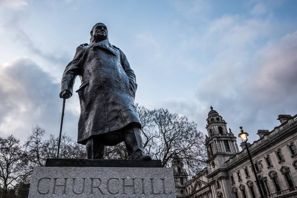 CLOSE, NO CIGAR: Churchill ON his pedestal IN London NEAR a building.