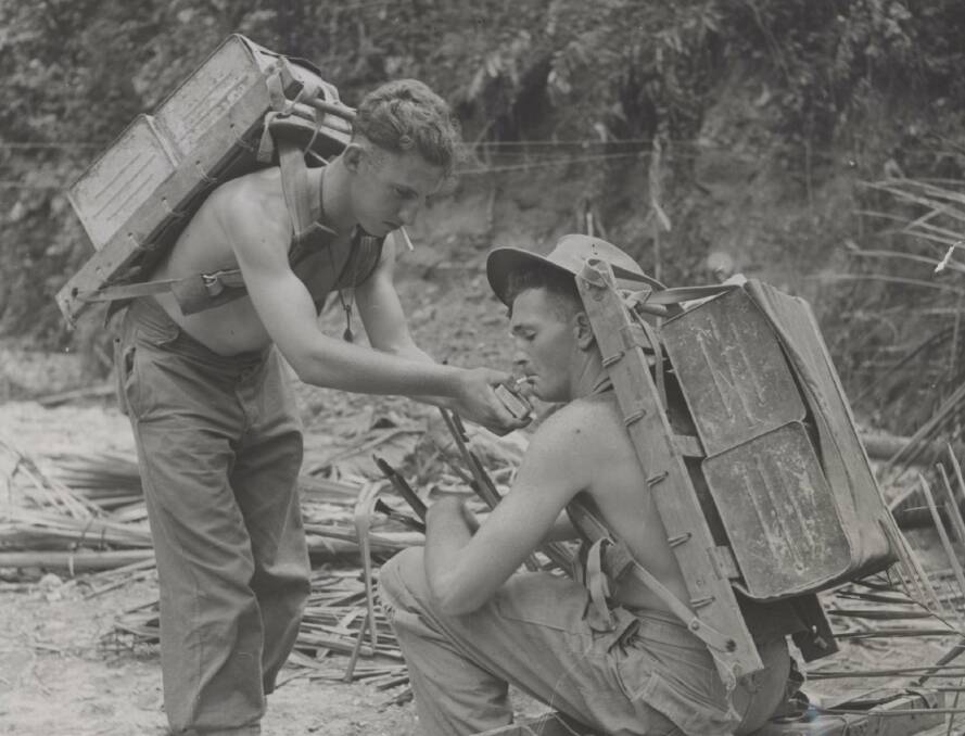 SMOKO: Two 2/1st Infantry Battalion water carriers pause for a smoke in Aitape in northern New Guinea. Image: University of Newcastle's Cultural Collections.