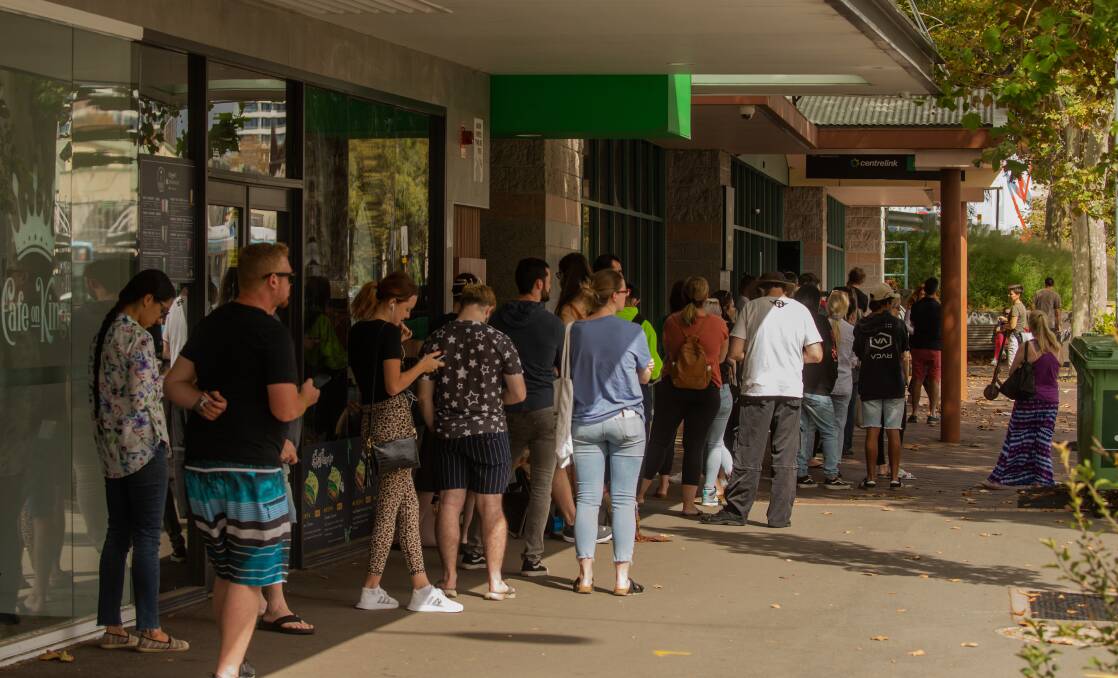 People queue outside the Newcastle Centrelink office on March 23, the day government restrictions shut down many businesses. Picture: Marina Neil