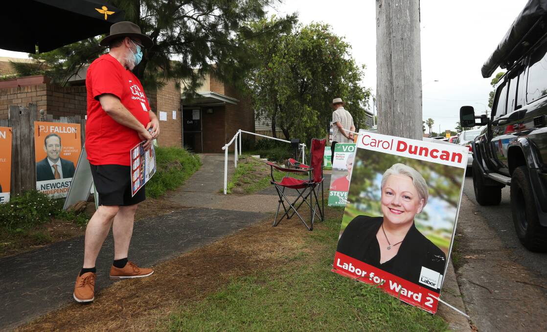 A Labor volunteer stands next to a sign promoting ward two candidate Carol Duncan outside an Adamstown voting booth on council election day in 2021. Picture by Simone De Peak 