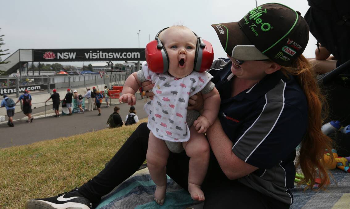 OPENING DAY: Swansea's Lizzy Ling holds seven-month-old Harrison as he reacts to cars speeding around the track. Picture: Simone De Peak