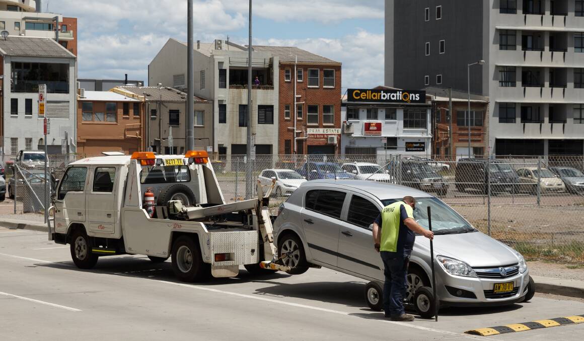 A car being towed from a street in Honeysuckle on Saturday afternoon. Picture: Max Mason-Hubers