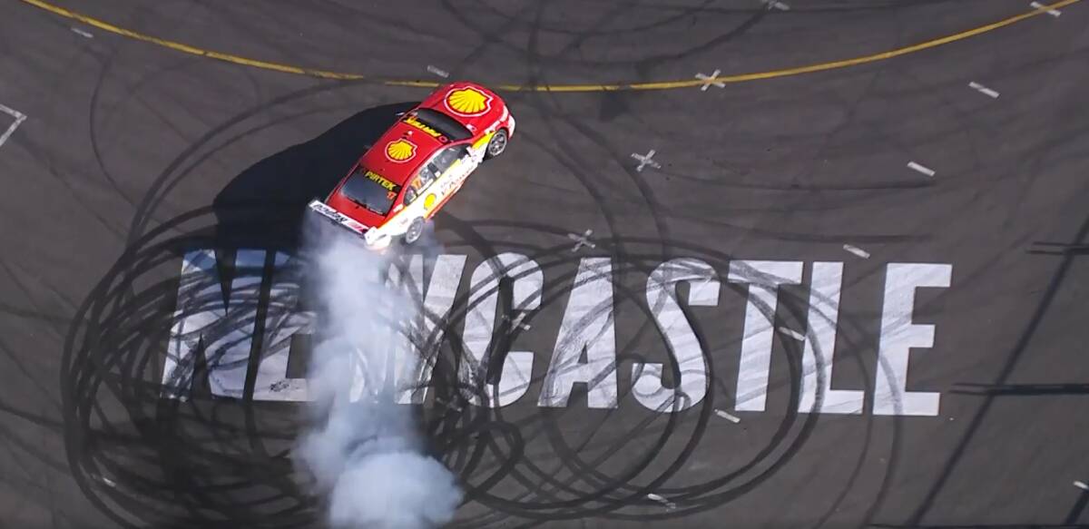 CIRCLE WORK: Scott McLaughlin celebrates wrapping up his first Supercars championship with a burnout on the Newcastle sign at the Nobbys beach hairpin.