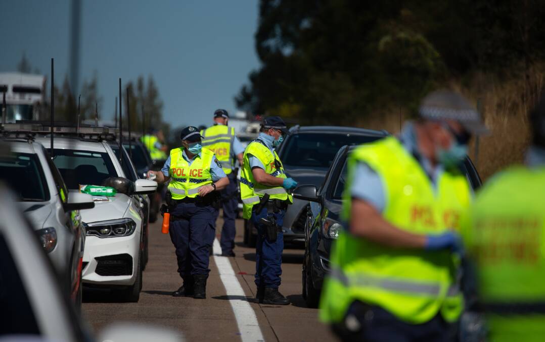 TAKING NOTICE: Police stopping northbound cars at a roadblock on the M1 motorway at Morisset in August. Picture: Marina Neil