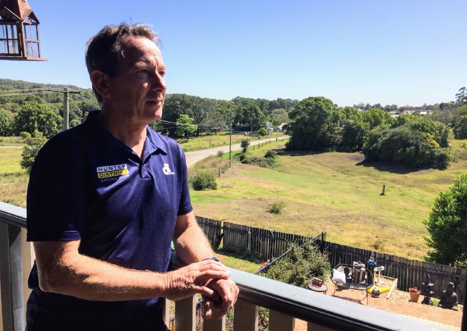 CLOSING IN: Nigel Perry looks out on the Minmi landscape from his balcony in Railway Street. Plans submitted to Newcastle council show his house will be surrounded by the new subdivision.