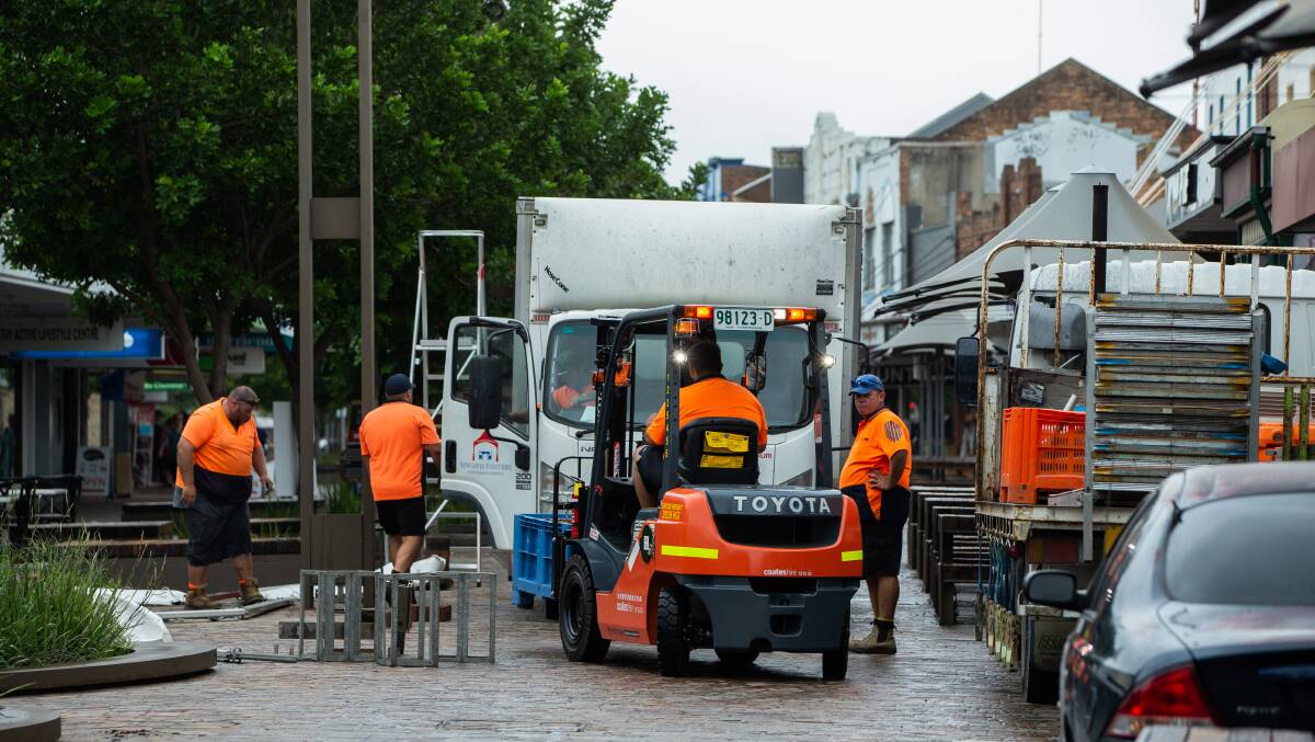 CALLED OFF: Workers dismantle Maitland's Taste festival, which was cancelled at late notice last weekend. Picture: Marina Neil 