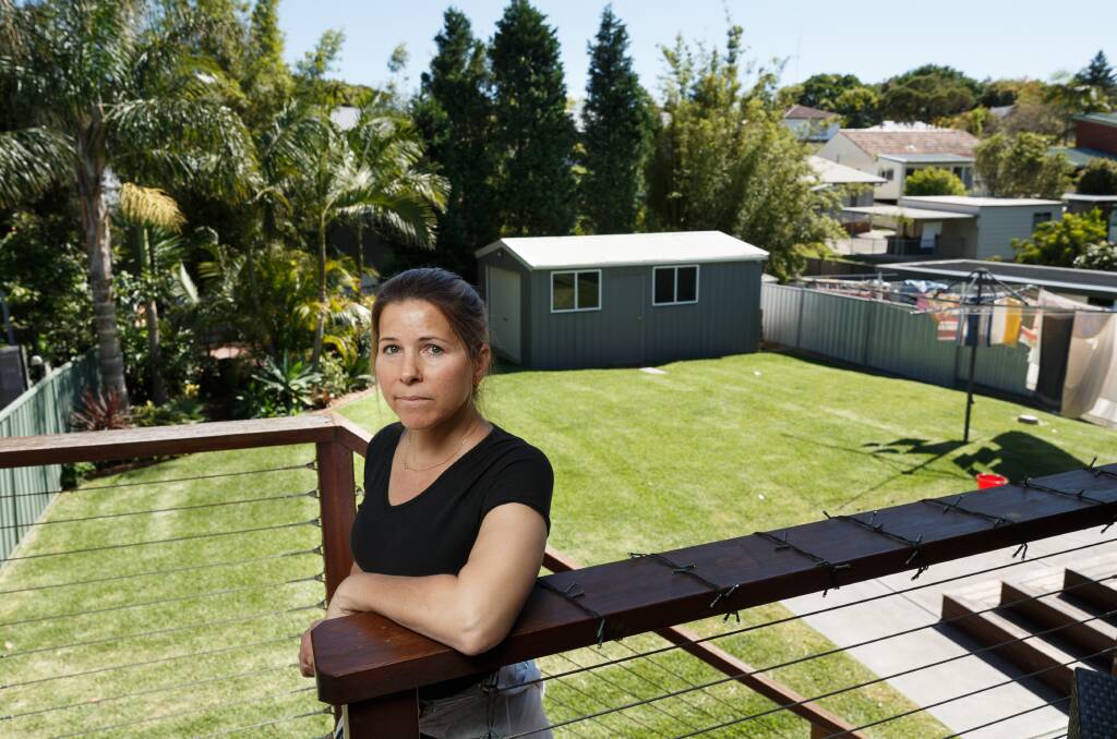 SPACE INVADERS: Kim Angeli on her back deck in Bryson Avenue, Kotara. She is concerned about the impact of townhouse developments on the suburb. Picture: Max Mason-Hubers