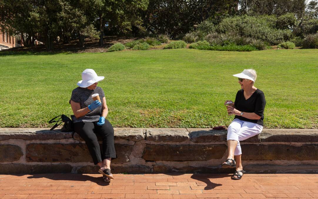Friends Jane Burke and Sharyn Brown catch up over coffee in Pacific Park on Tuesday. Picture: Max Mason-Hubers 