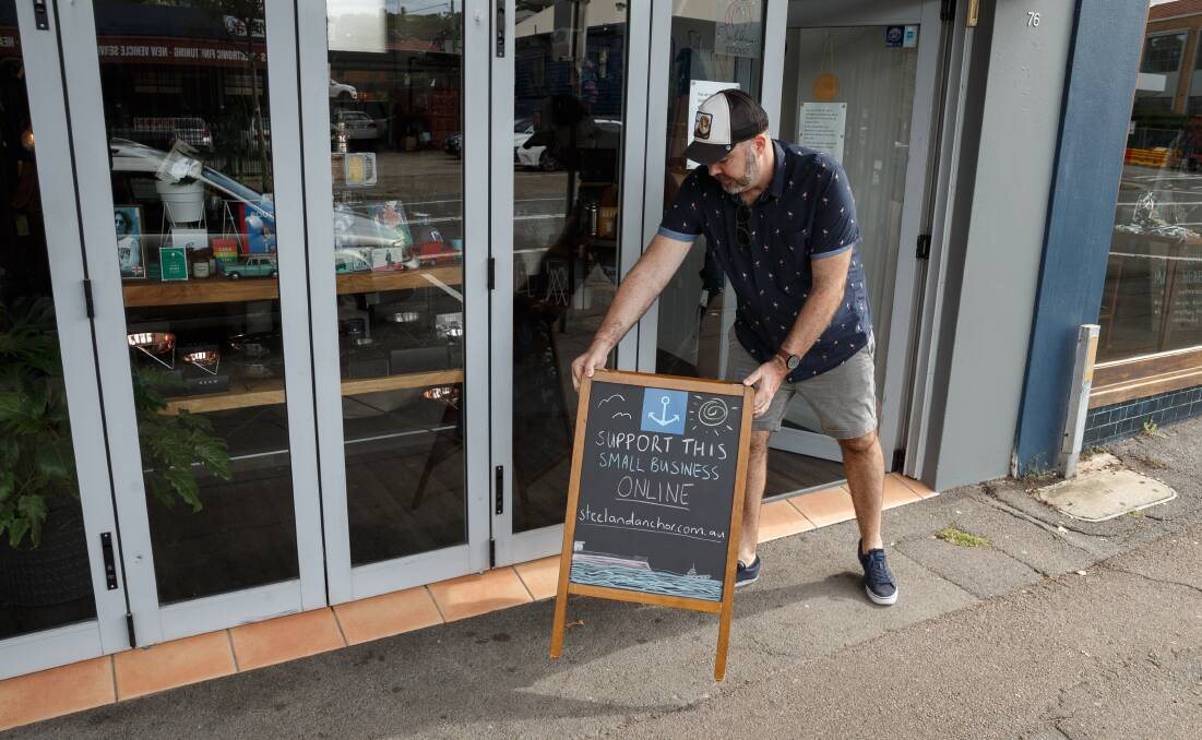 STILL FIGHTING: Darby Street shopkeeper Troy Pezely puts out a sign promoting the Steel & Anchor online business on Wednesday. Picture: Max Mason-Hubers