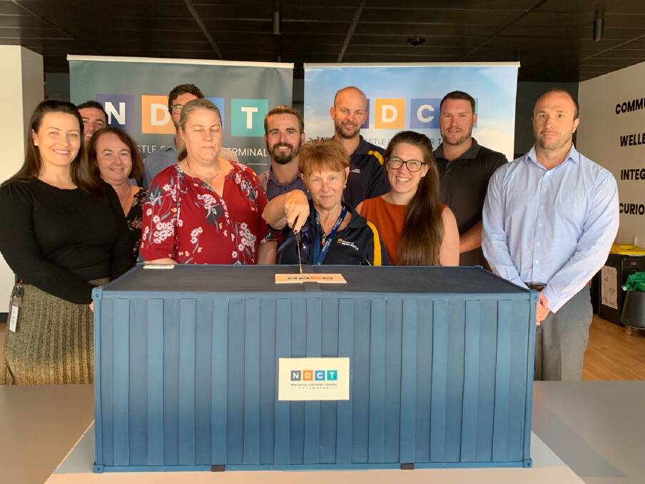 Port of Newcastle staff with the container-shaped cake which was meant to celebrate a $250 million federal funding announcement on May 6. The former government cancelled the announcement at the last minute.