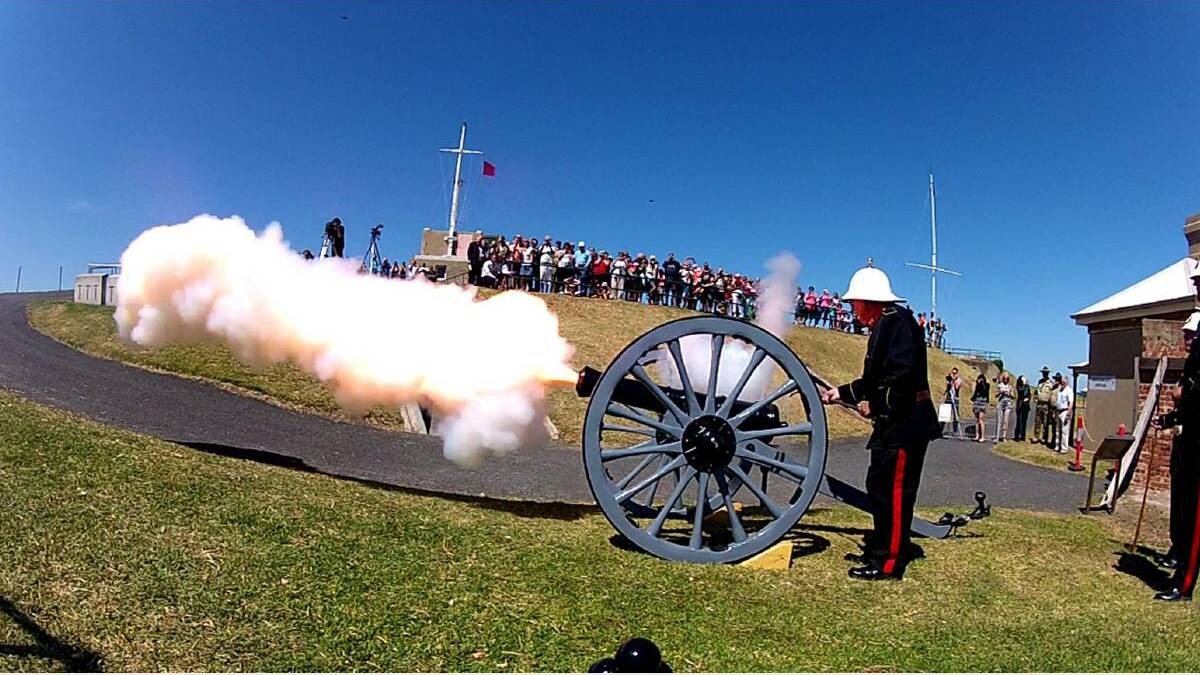 FIRE IN THE HOLE: The Fort Scratchley time gun goes off with a bang as a crowd looks on. Picture: Darren Pateman