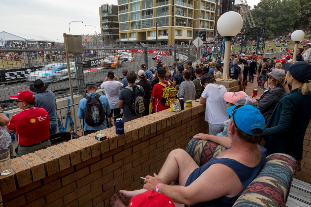 MIXED VIEW: Fans watch Sunday's Newcastle 500 Supercars race from a balcony on Shortland Esplanade. Picture: Max Mason-Hubers