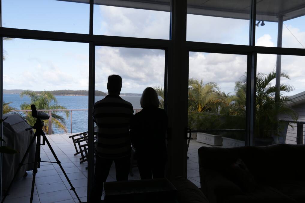'LIKE LIVING NEXT DOOR TO A PUB': Chris and Nicky Burgess in their living room looking out to Pulbah Island. They say the short-term rental house next door has ruined their peace and quiet. Picture: Jonathan Carroll 