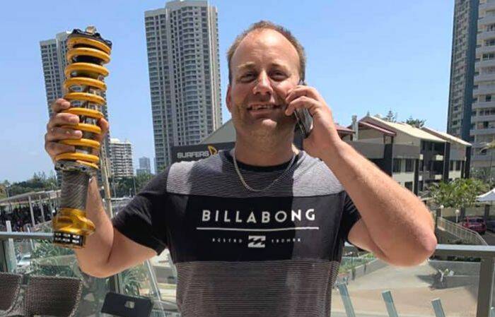 NEAR MISS: Race fan Andrew Went holds up the shock absorber that flew onto his hotel balcony on the Gold Coast.