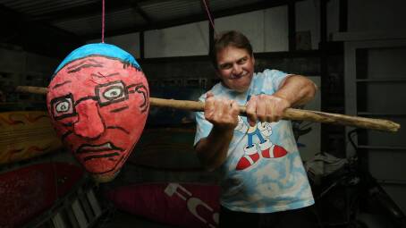 POLITICAL BASH: Dean Harris has a crack at a Scott Morrison and Clive Palmer pinata at a mate's election party in Newcastle on Saturday night. Picture: Simone De Peak