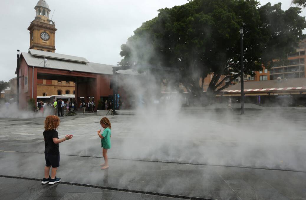 Children play in the mist tracks at The Station Piazza as Rob Stokes launches the public space on Wednesday. Picture: Simone De Peak