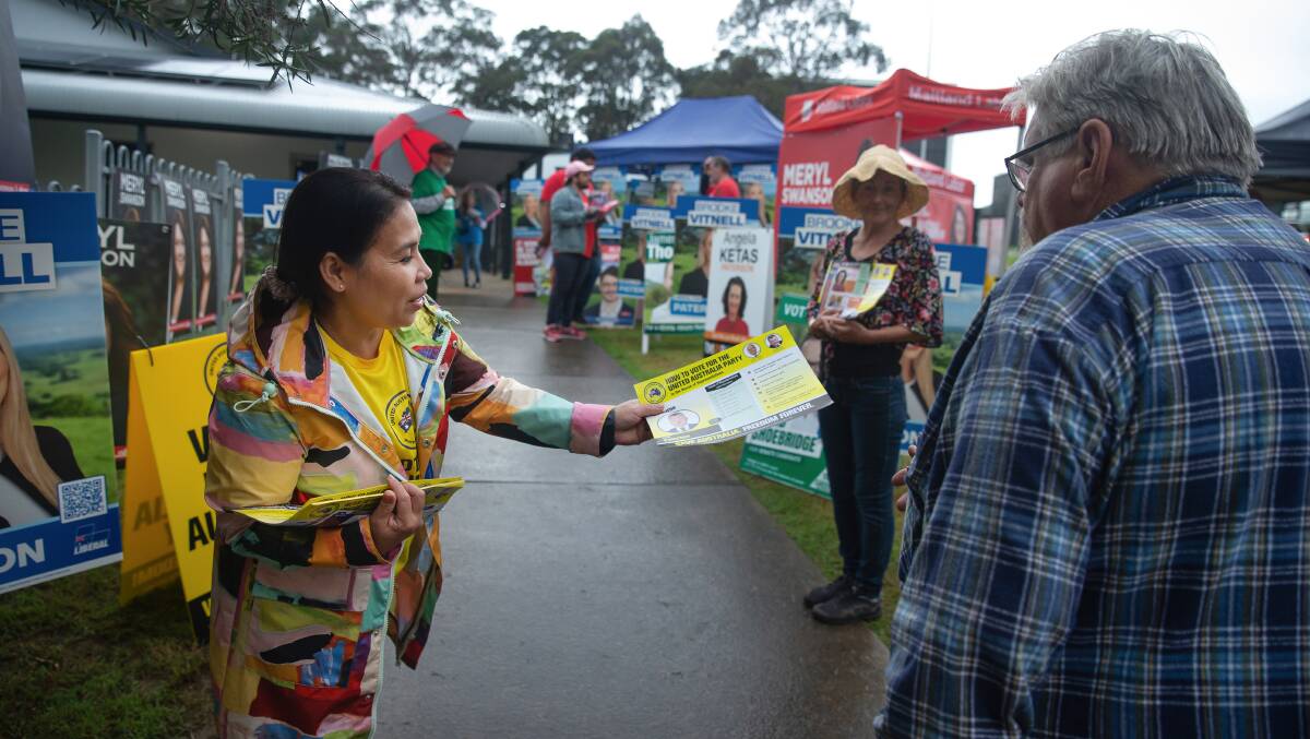 ALL IN ORDER: A United Australia Party volunteer handing out how-to-vote cards at East Maitland pre-poll on Thursday. Picture: Marina Neil