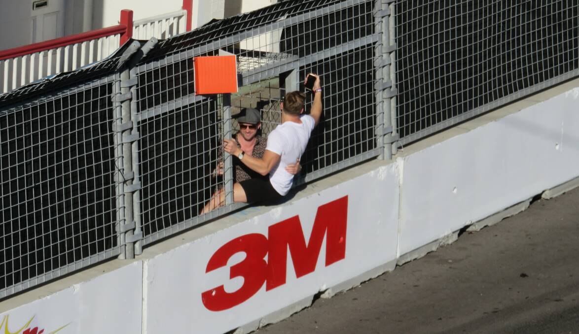 A man takes selfies from a gap in the fence during last year's race. 