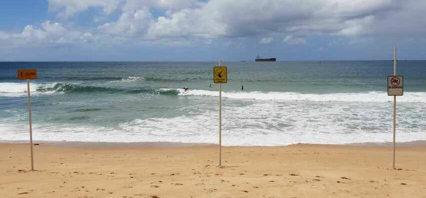 Warning signs have not deterred people from surfing where the tank traps lurk in the water. Picture: Anthony Lilley