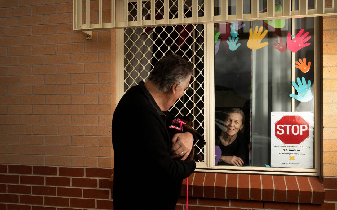 SAFE DISTANCE: John Neil visits his wife, Hetty, who has dementia and lives at Uniting Lindsay Gardens aged care home at Hamilton. Picture: Marina Neil