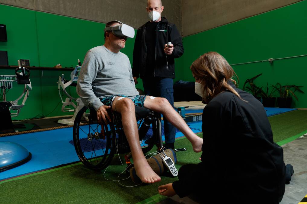 Tech in action: Angus McConnel gets hooked up to virtual reality equipment at Engage VR in Mayfield West. Pictured at back, Rohan O'Reilly. Picture: Max Mason-Hubers