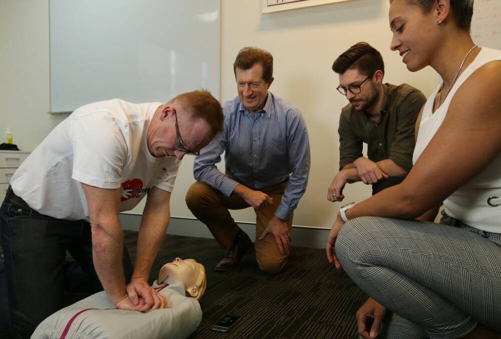 Hands on: Dr Mark Miller and Dr David Durrheim demonstrate CPR to Hunter Valley Coal Chain Coordinator employees in Broadmeadow on Monday. Picture: Simone De Peak