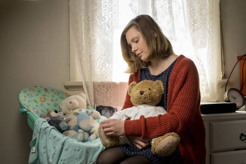 Shattered: Brianna Hudson sits with a teddy bear that holds the ashes of her stillborn baby, James Zachary Doege. She hopes people who have experienced a similar loss will join her family at the Pregnancy and Infant Loss Remembrance Evening on October 15. Picture: Peter Stoop