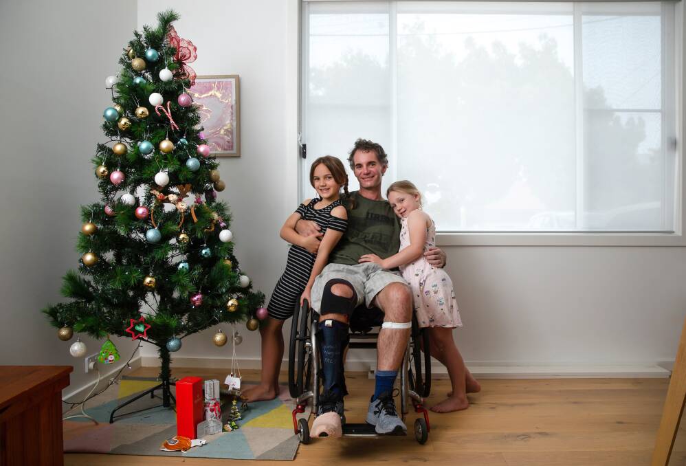 A Christmas wish: Chris Apps is back at home in Lake Macquarie with his daughters, Ruby and Peppa, after six months in Sydney trying to recover from a spinal cord injury to his lower neck (C6-7). Picture: Marina Neil