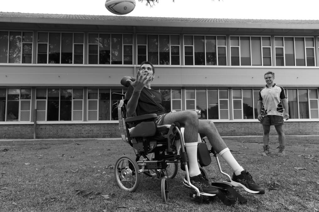 Road to recovery: Lawson Rankin with with friend Tarj Lyle, tossing a football with a group of mates (not shown) at the Rankin Park Centre. Picture: Max Mason-Hubers