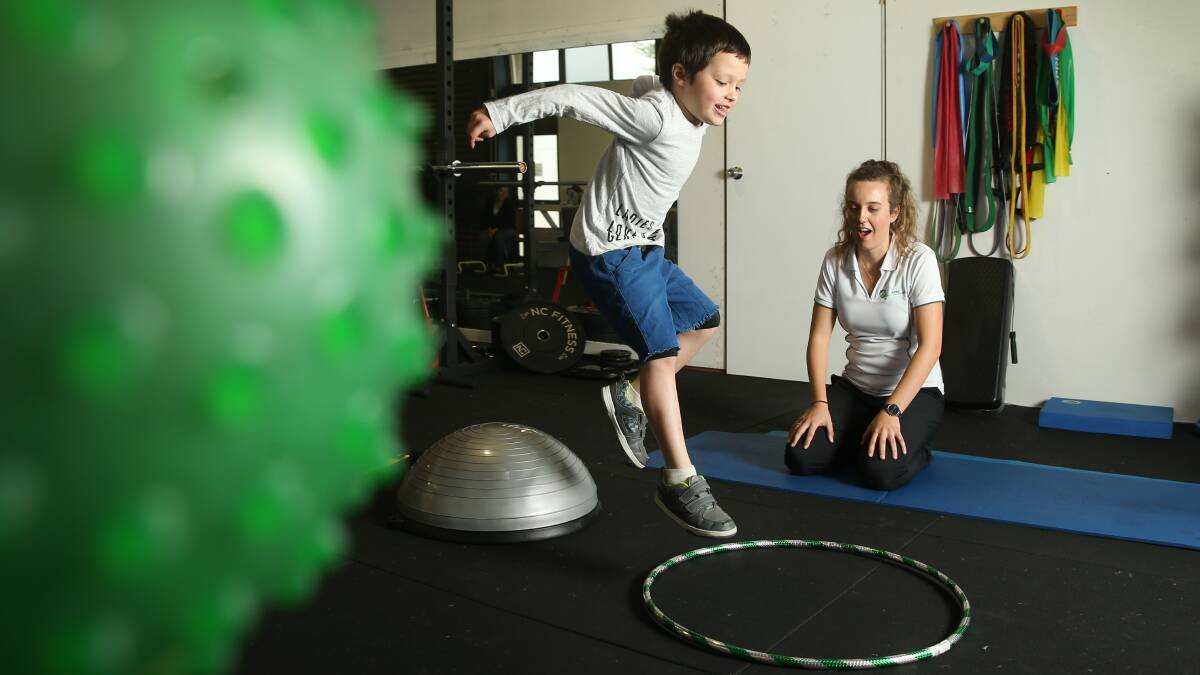 Leaps and bounds: Aidan Jelenic, 5, with exercise physiologist Eden Macneill, of Hunter Rehabilitation and Health. Picture: Marina Neil