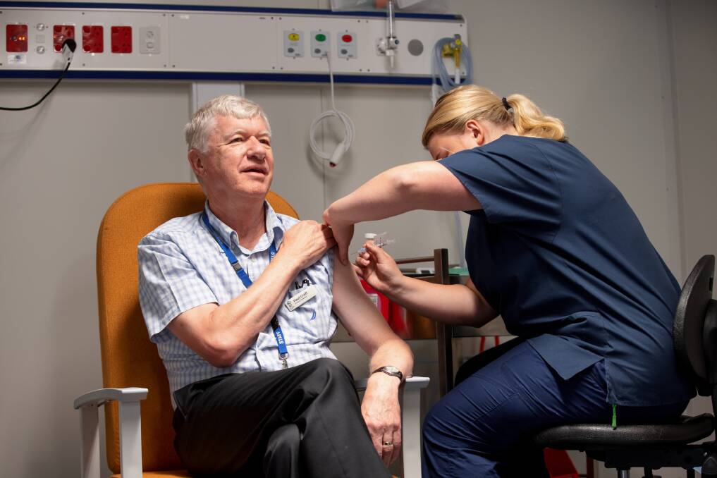 Ready to roll: Registered nurse Sophie Poole administers the AstraZeneca vaccine to clinical director at Canberra Hospital's cancer centre Dr Paul Craft last week. Picture: Sitthixay Ditthavong