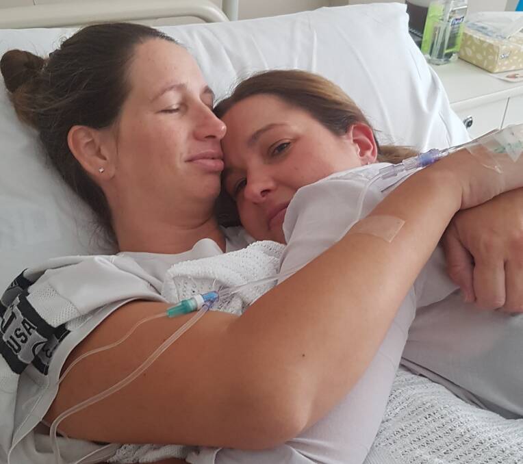 Grateful: Craig Darken captured the moment Rebecca Crisp, left, and Kristy Darken, who was born without a uterus, shared a hug soon after the birth of Henry.