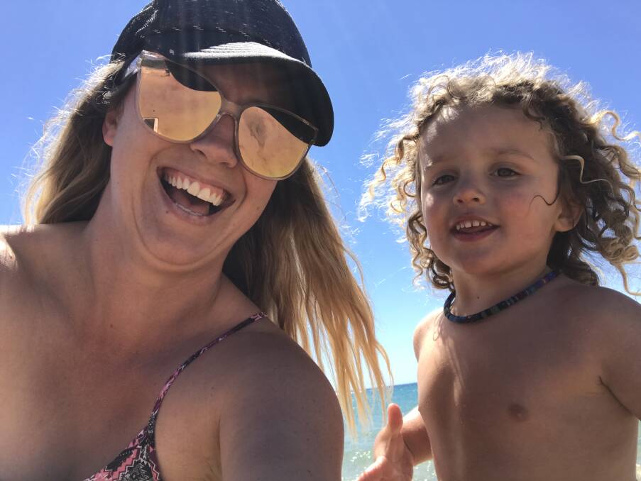 Beach boy: Nicole Fuller, with Vinnie, at the beach. Vinnie had been playing happily at the beach in the days before he was flown to Newcastle for treatment.