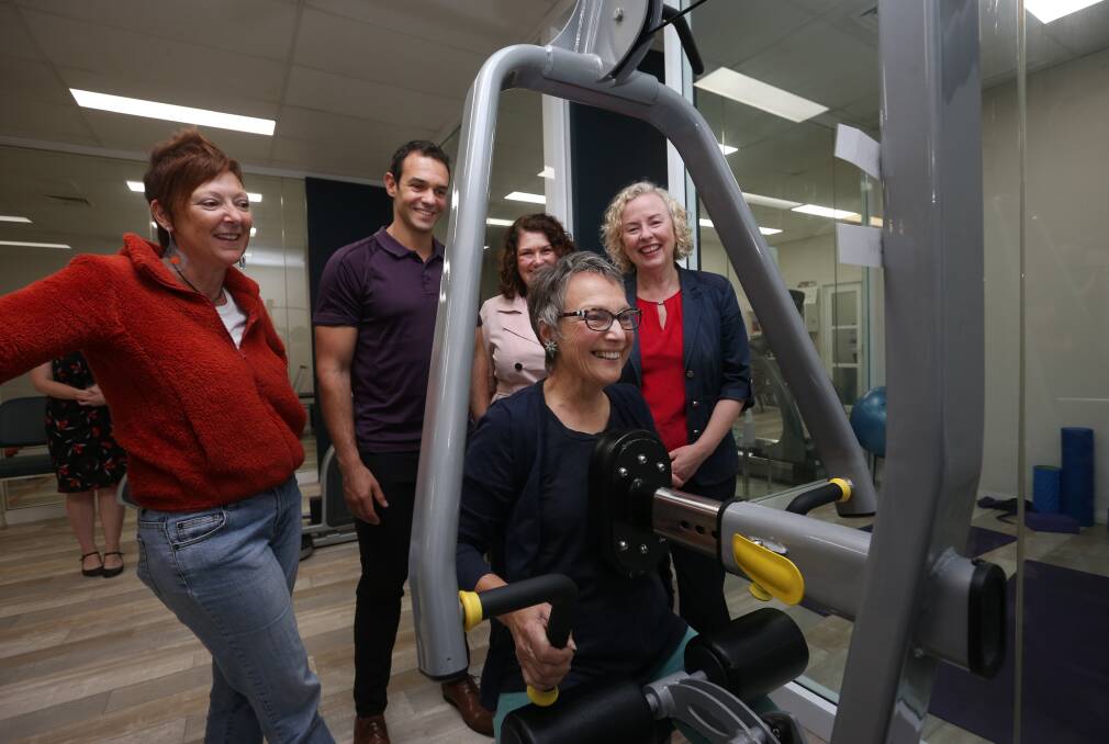 Lifeline: From left, former client Nicola Hirschhorn, physio and acting managing director Loukas Nadiotis, Meryl Swanson MP, Sharon Claydon MP, watch on as client Margie Pink demonstrates a weights session. Picture: Simone De Peak