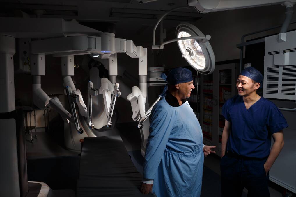 Grateful: Peter Baker, of Kahibah, pictured with Dr Albert Tiu and the da Vinci XI surgical robot that helped build his new bladder. Mr Baker urged people not to ignore symptoms of bladder cancer after he was diagnosed in March. Picture: Max Mason-Hubers