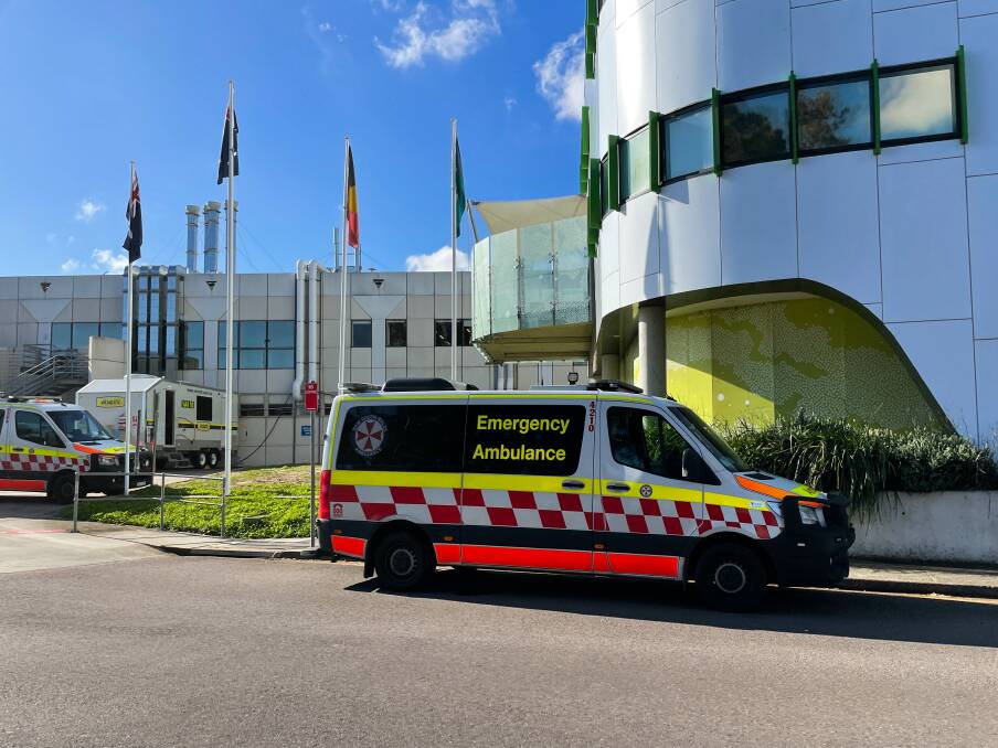 Bed blocked: The John Hunter Hospital's ambulance bay was overflowing around lunchtime on Thursday, with vehicles having to park in no stopping bays and turning lanes. Picture: Jonathan Carroll