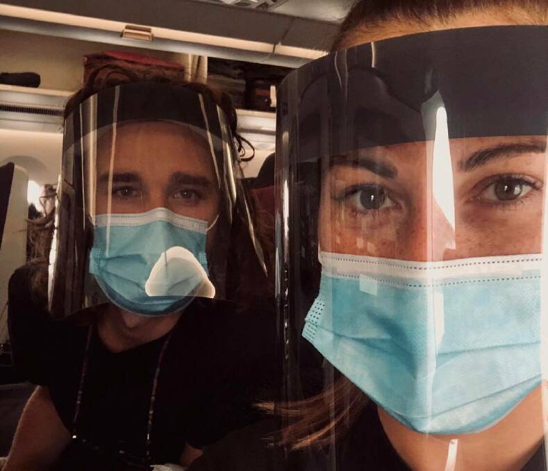 The mask: Tiarne Gillespie and Sean Brocklesby on the first leg of their flight home from London to Doha. Photo: supplied