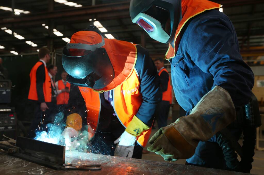 Having a go: Scott Morrison tries his hand at welding at the Varley workshop at Tomago. Picture: Simone DePeak. 