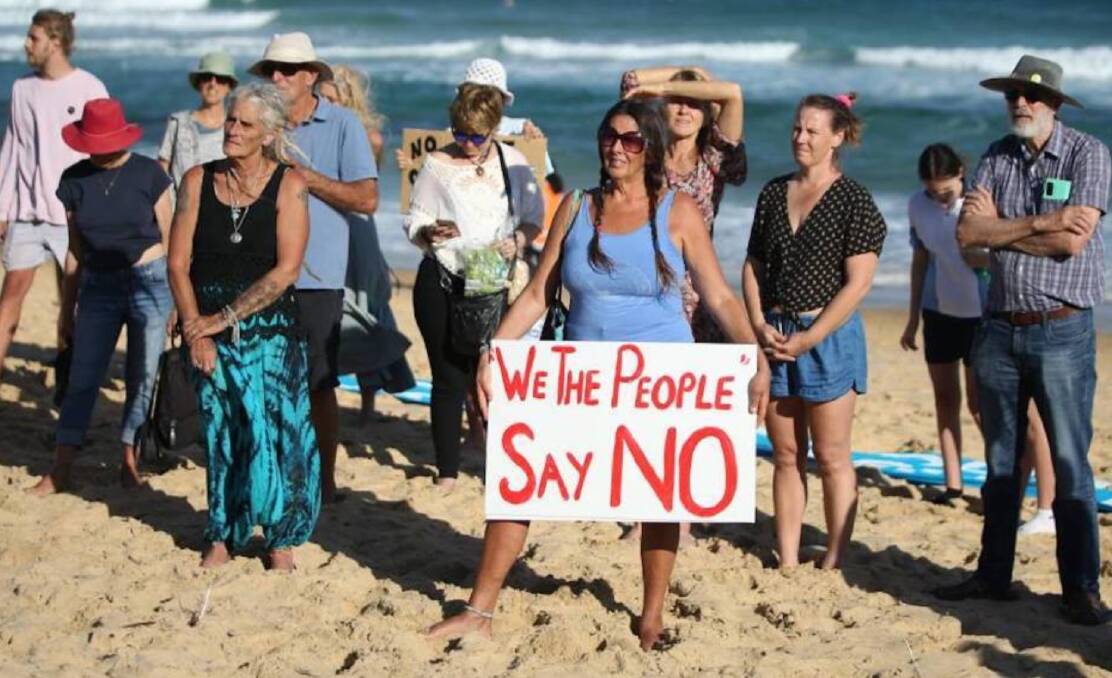 People power: A protester holds a sign at an anti-PEP-11 rally at Bar Beach in February. Community opposition to the project has grown steadily in recent years. 